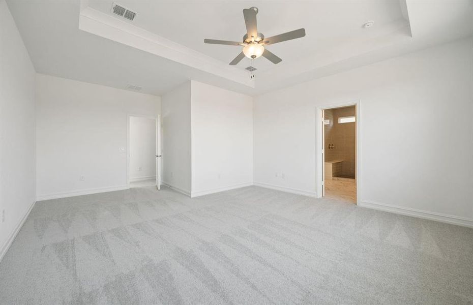 Expansive owner's suite with impressive windows and elegant tray ceiling  *Real home pictured