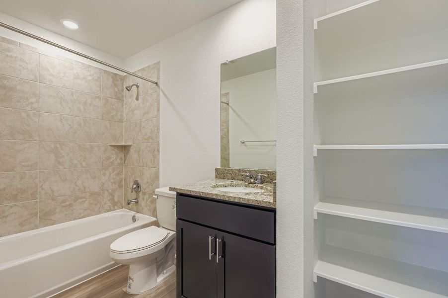 Bathroom with light wood-type flooring, vanity, and washtub / shower combination Bathroom with light wood-type flooring, vanity, and washtub / shower combination