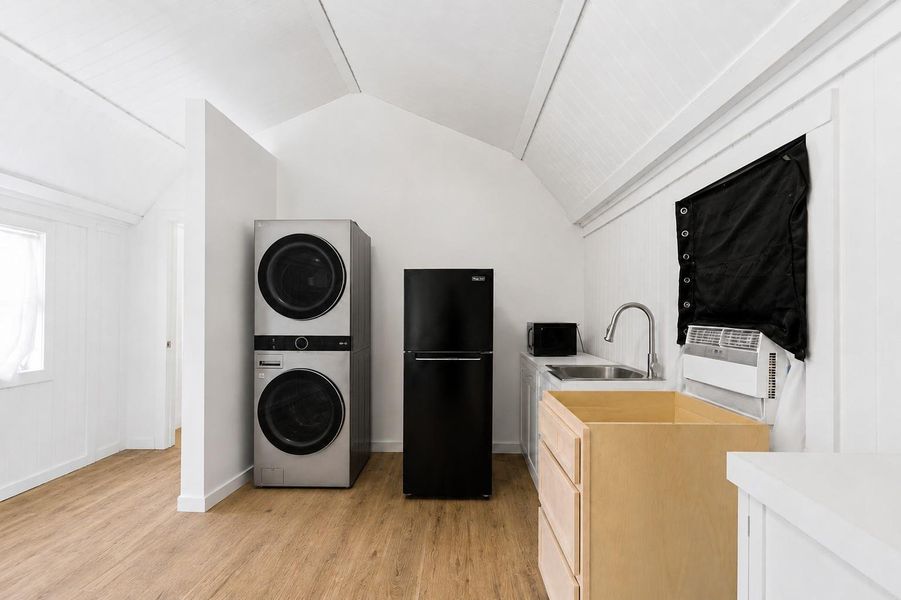 Modern appliances complete this functional, light-filled utility space with new flooring and crisp white walls.