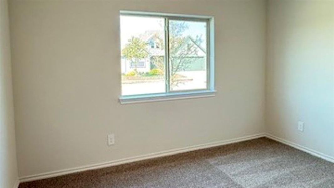 Unfurnished room featuring dark colored carpet and baseboards