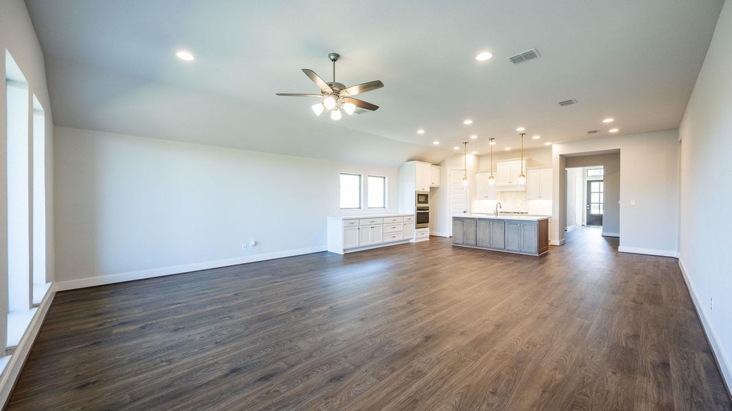 Unfurnished living room with recessed lighting, vaulted ceiling, dark wood-type flooring, and a ceiling fan