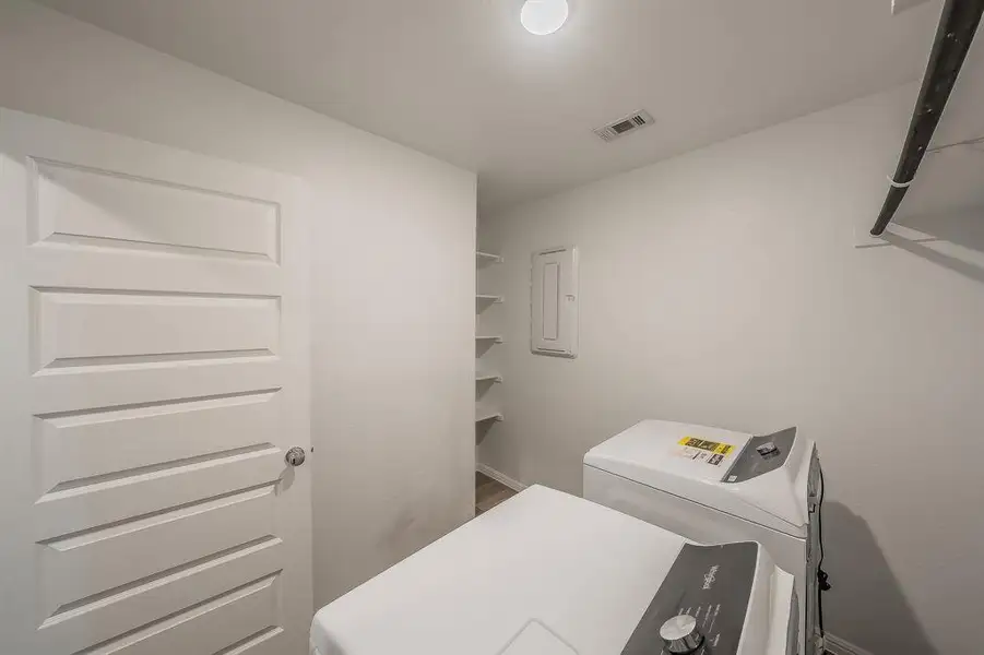 Laundry room featuring washer and dryer and electric panel Laundry room featuring washer and dryer and electric panel