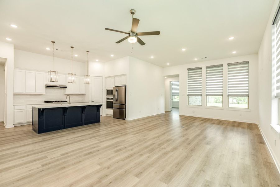 Open-concept living space featuring a seamless transition from the spacious family room to the formal dining area, private rear office, and expansive covered patio.
