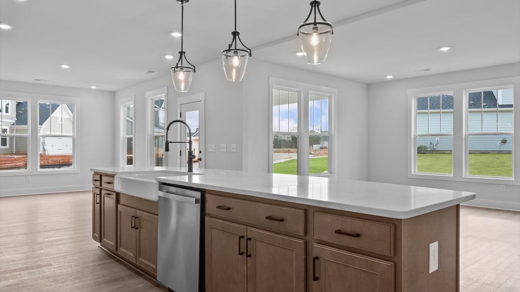 Accomplished kitchen design featuring pendant lighting above a statement island for both prep and gathering