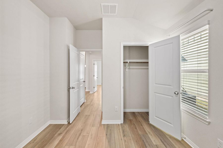 Unfurnished bedroom featuring light wood-type flooring, a closet, and lofted ceiling Unfurnished bedroom featuring light wood-type flooring, a closet, and lofted ceiling