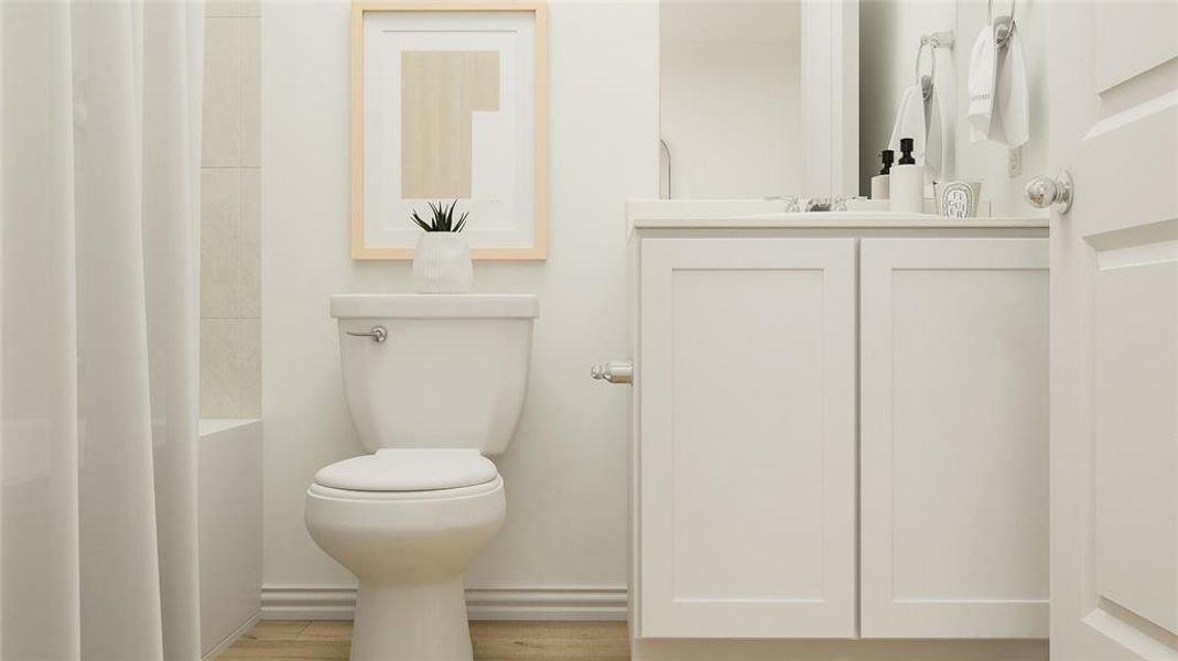 Bathroom featuring hardwood / wood-style floors, vanity, and toilet