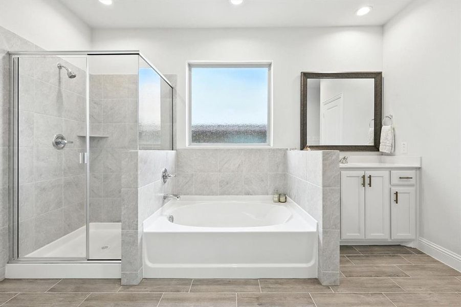 Full bathroom featuring a bath, vanity, a stall shower, recessed lighting, and wood finish floors