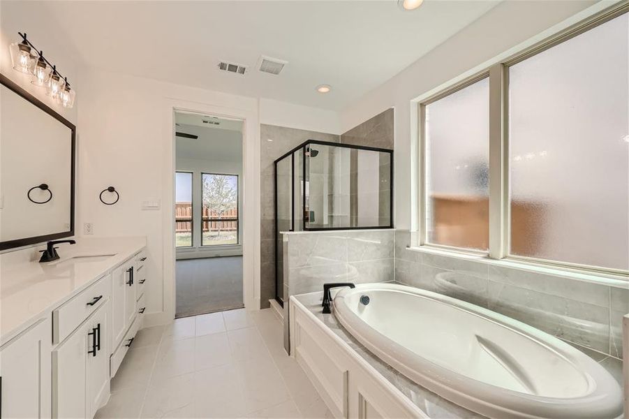 Bathroom with vanity, independent shower and bath, and tile patterned floors