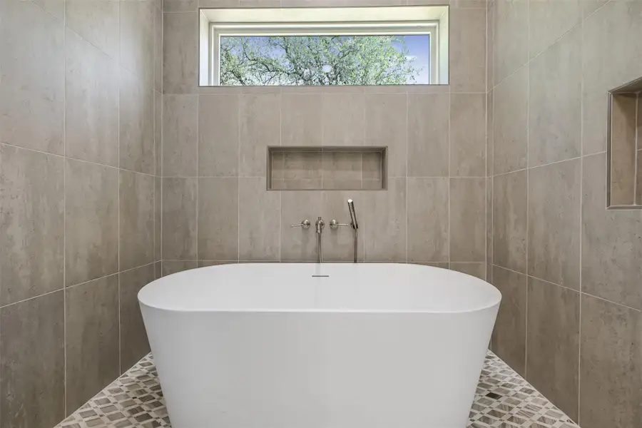 Full bath with a freestanding tub and plenty of natural light
