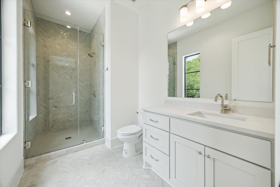 En-suite bath - has enclosed walk-in shower and quartz countertop.