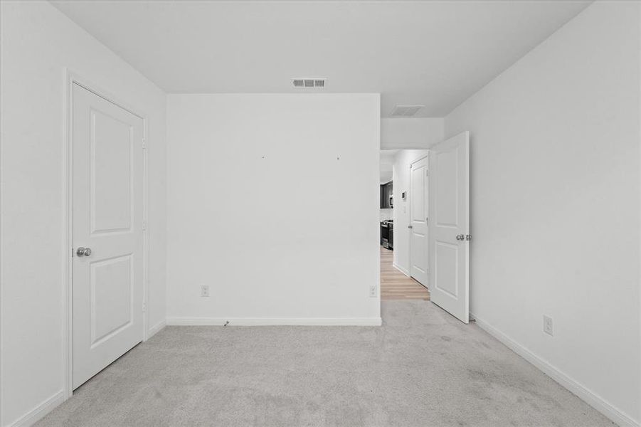 Empty room featuring light colored carpet