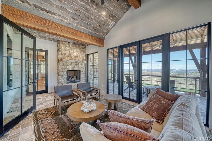 The four-seasons room features a fireplace and cobblestone flooring. The four-seasons room features a fireplace and cobblestone flooring.