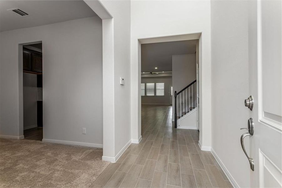 As you enter the home, you're greeted by a bright and airy hallway that leads to the main living areas. The open layout and high ceilings provide a sense of spaciousness, while the modern tile flooring offers a seamless transition from room to room. This entryway sets the tone for the rest of this lovely home. Photos are from another Rylan floor plan.