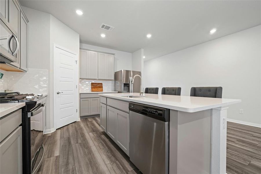 Stainless Steel Appliances and Quartz Counters with Undermount Sink at Eat-in Kitchen