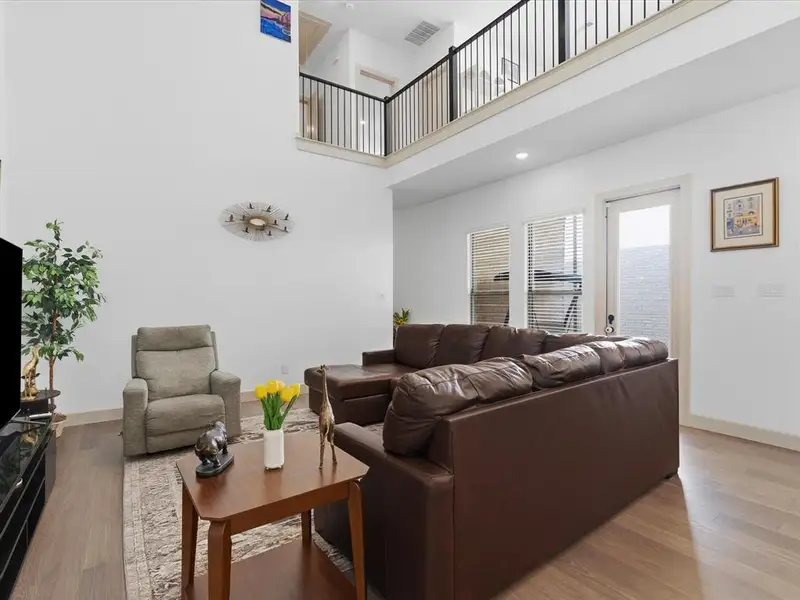 Two-story living area featuring a light wood-finish floor and white walls