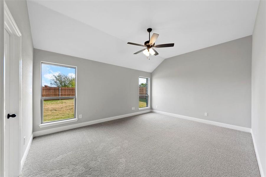 Spare room featuring carpet, ceiling fan, and lofted ceiling