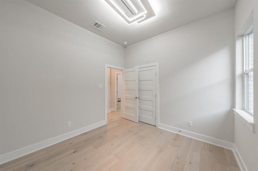 Spare room with cooling unit and light wood finished floors