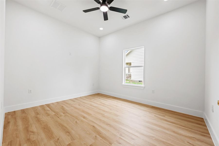 Room featuring wood-finish flooring, white walls, and a single window with horizontal blinds