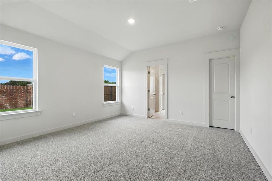 Unfurnished bedroom featuring carpet and lofted ceiling Unfurnished bedroom featuring carpet and lofted ceiling
