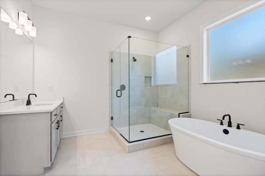 Bathroom featuring a soaking tub, a stall shower, vanity, light tile patterned flooring, and recessed lighting Bathroom featuring a soaking tub, a stall shower, vanity, light tile patterned flooring, and recessed lighting