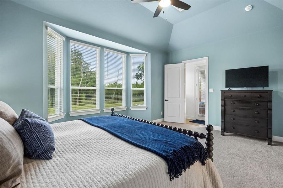 Room featuring a bay window, vaulted ceiling, and ceiling fan Room featuring a bay window, vaulted ceiling, and ceiling fan