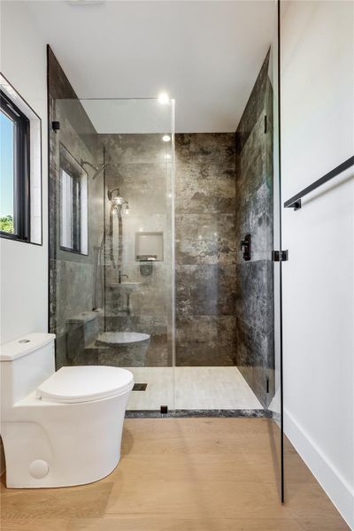 Full bathroom featuring a stall shower and wood finished floors