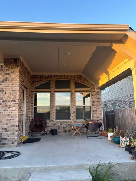 This property features an inviting covered patio with a concrete floor, brick exterior, and recessed lighting