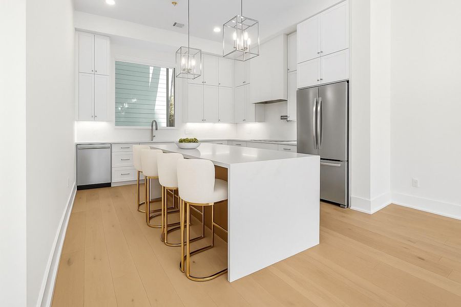 Kitchen - Your view from the dining room to the living room with access to your balcony. -  Come tour our furnished model home open Saturday & SundayEstimated completion November 30, 2025.