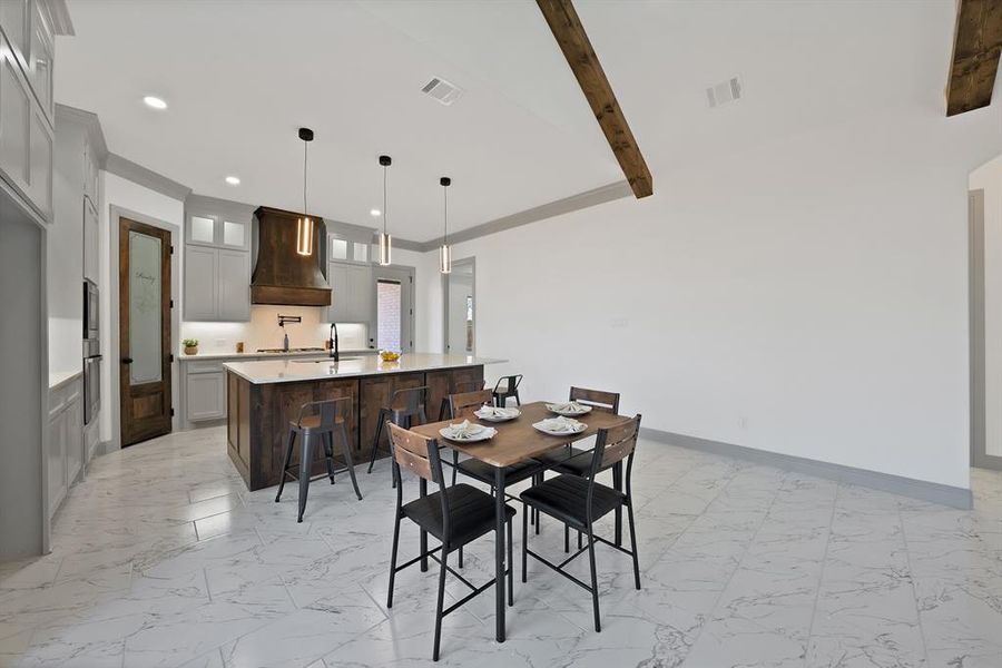 Dining room with light marble finish flooring, beam ceiling, and recessed lighting
