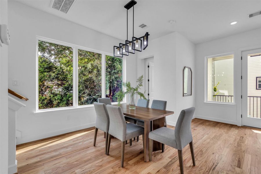 The inviting dining area is bathed in natural light from expansive windows, perfectly blending sleek design with a warm ambiance. The inviting dining area is bathed in natural light from expansive windows, perfectly blending sleek design with a warm ambiance.