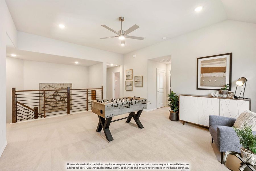 Upstairs game room with foosball table, ceiling fan, carpet flooring, and open railing overlooking lower level Upstairs game room with foosball table, ceiling fan, carpet flooring, and open railing overlooking lower level
