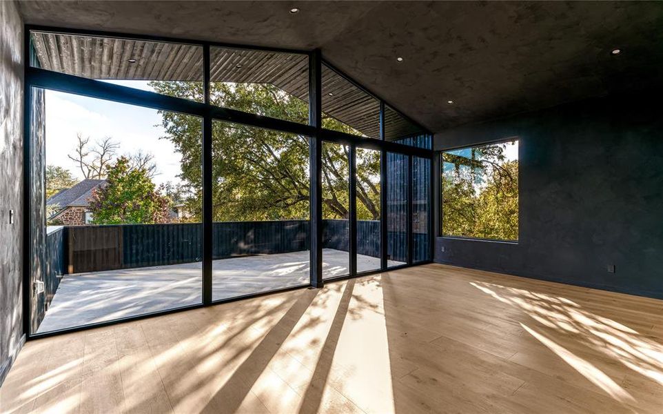Flex room with patio, vaulted ceiling, flooded with natural light and lime wash walls.