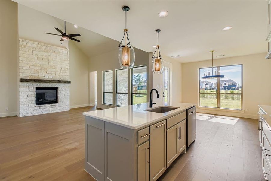 Kitchen with light wood-style floors, ceiling fan, lofted ceiling, gray cabinetry, and light countertops