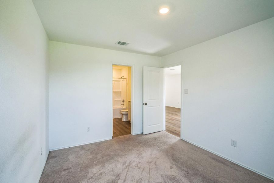 A well-lit bedroom provides direct access to a functional private bathroom. A well-lit bedroom provides direct access to a functional private bathroom.