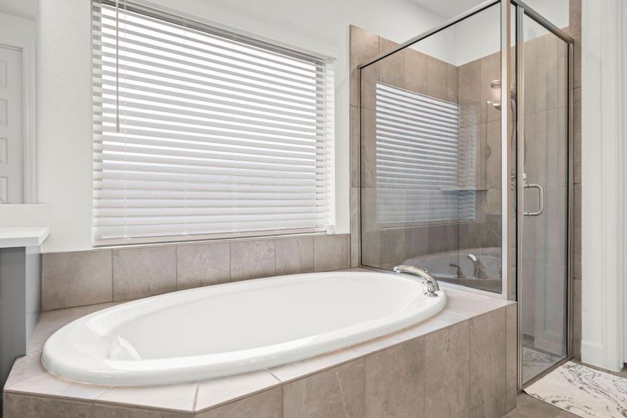 Your Owners’ en suite is a tranquil retreat designed for ultimate relaxation. The soaking tub is the perfect spot to unwind, while the separate shower with a corner seat and toiletry shelf offers a refreshing experience and boasts both main and hand-held shower heads.