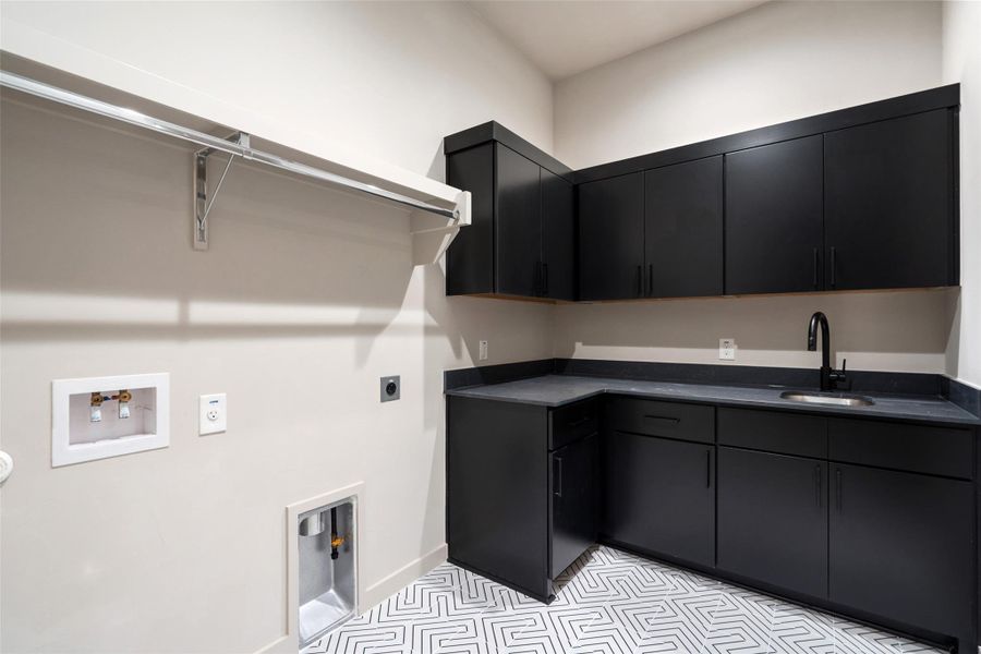 A dedicated laundry room features functional storage, a sink, and stylish patterned tile flooring. A dedicated laundry room features functional storage, a sink, and stylish patterned tile flooring.
