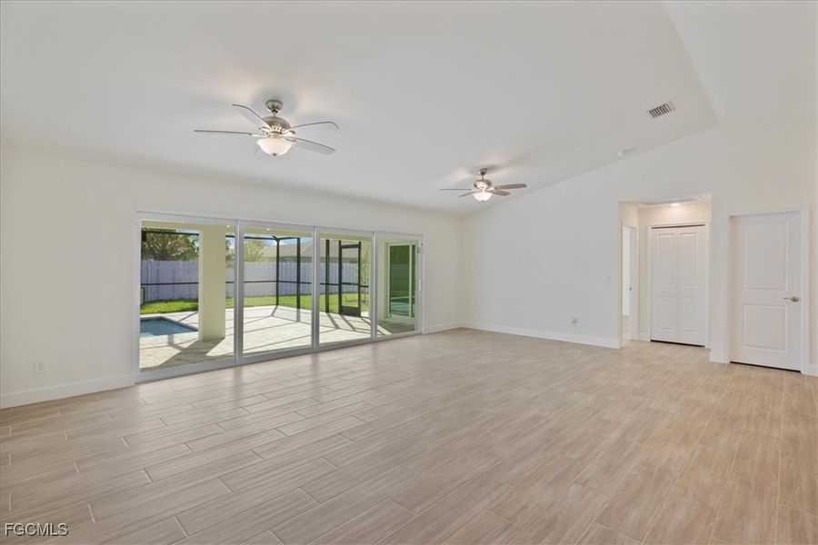 Spare room featuring a ceiling fan, wood finish floors, and vaulted ceiling
