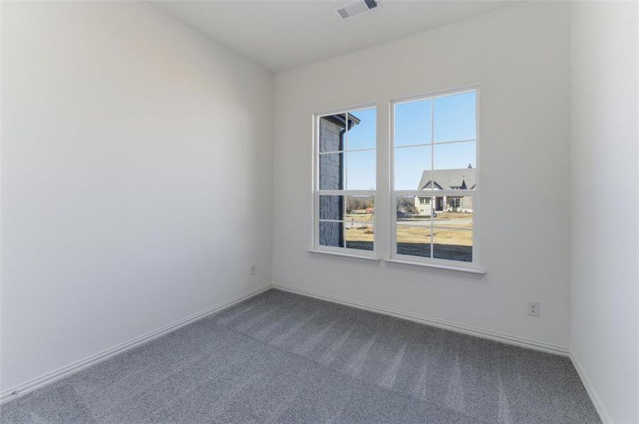 Carpeted spare room with baseboards