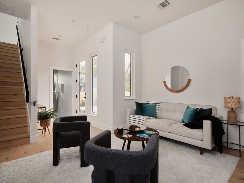 Living room featuring light wood-style floors and stairs Living room featuring light wood-style floors and stairs