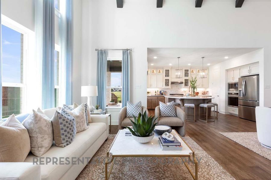 Living area featuring a high ceiling, dark wood-style flooring, and recessed lighting Living area featuring a high ceiling, dark wood-style flooring, and recessed lighting