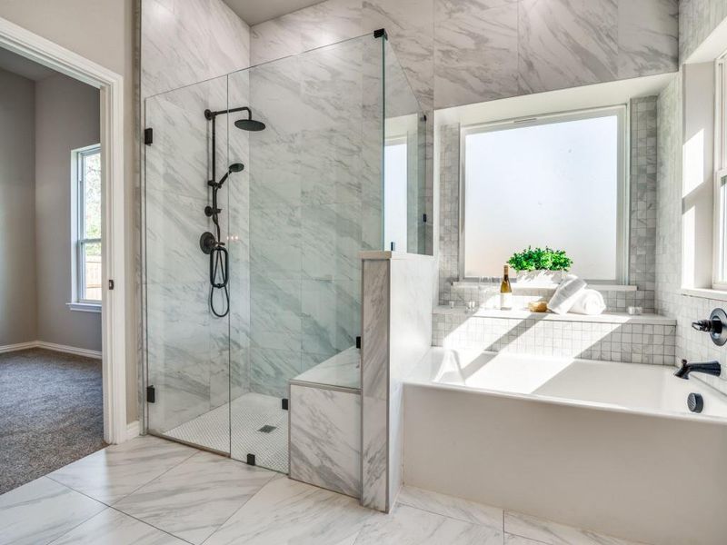 Bathroom with marble finish floor, a bathing tub, a marble finish shower, and baseboards Bathroom with marble finish floor, a bathing tub, a marble finish shower, and baseboards