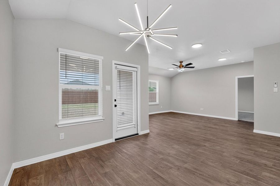 Rich wood flooring anchors this airy, open-concept living space with neutral walls.