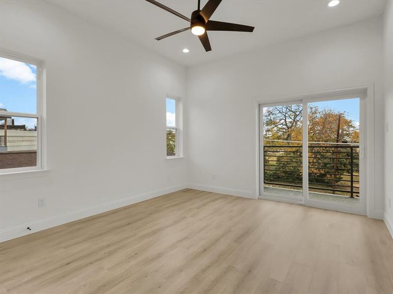 Empty room featuring light hardwood / wood-style floors, a wealth of natural light, and ceiling fan