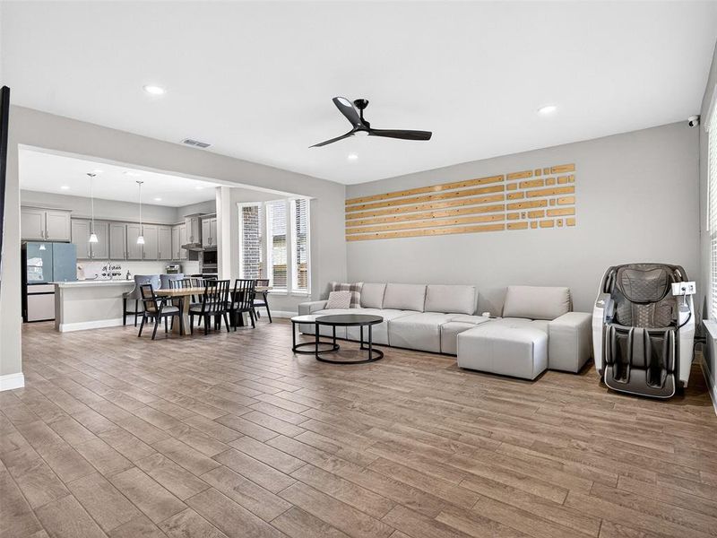 Open-concept living space featuring wood-finish plank flooring, recessed lighting, and a contemporary ceiling fan Open-concept living space featuring wood-finish plank flooring, recessed lighting, and a contemporary ceiling fan