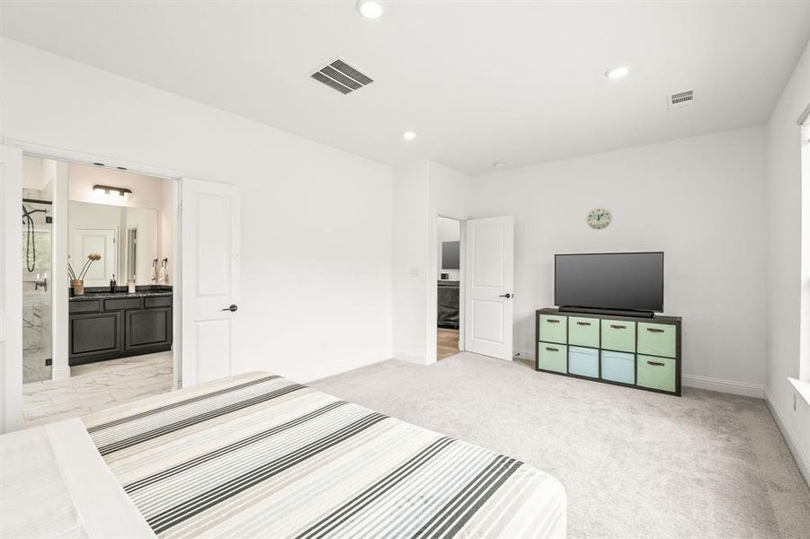 Unfurnished bedroom featuring light carpet, recessed lighting, and ensuite bath