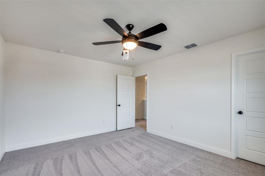 Unfurnished room with carpet flooring and a ceiling fan Unfurnished room with carpet flooring and a ceiling fan