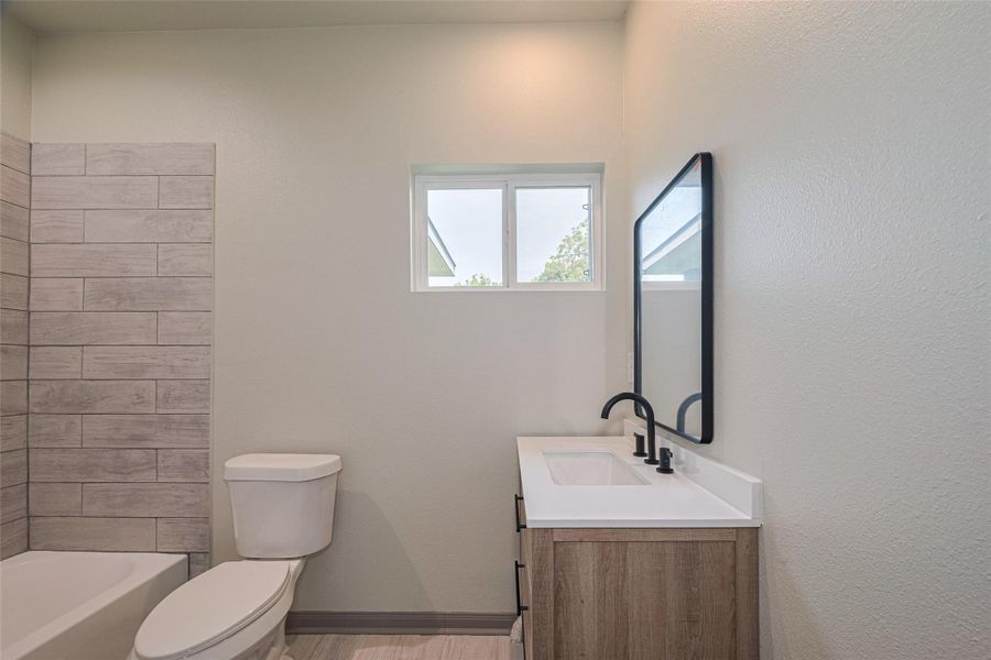 Stylish secondary bathroom with modern fixtures and a chic wood vanity. Stylish secondary bathroom with modern fixtures and a chic wood vanity.