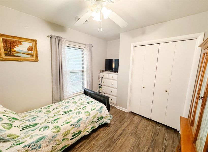 Bedroom featuring dark wood finished floors, ceiling fan, and a closet