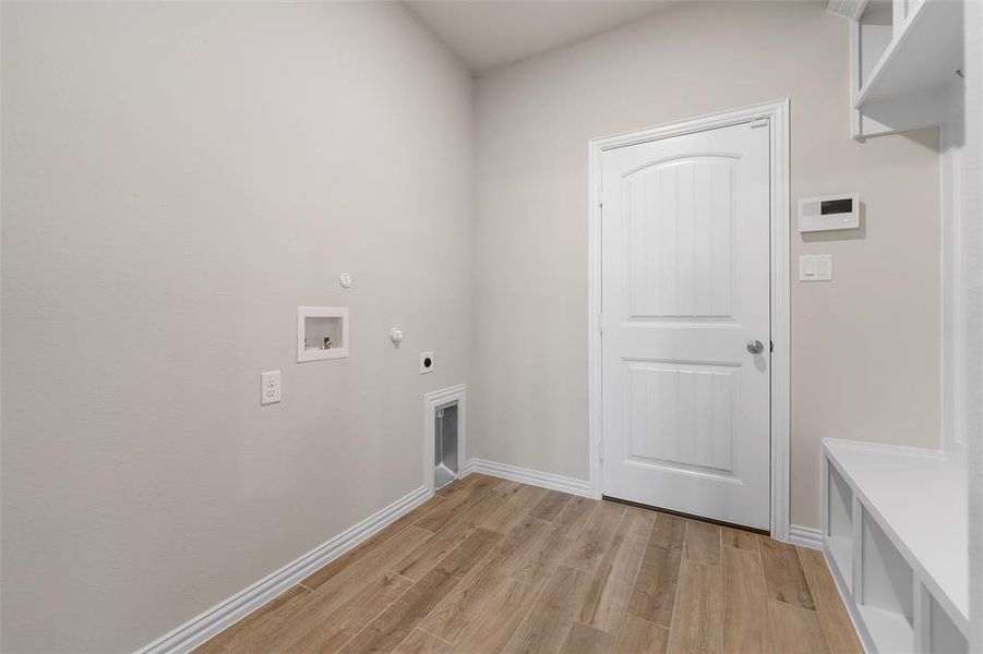 Laundry area featuring hookup for a gas dryer, light wood finished floors, hookup for a washing machine, and electric dryer hookup Laundry area featuring hookup for a gas dryer, light wood finished floors, hookup for a washing machine, and electric dryer hookup