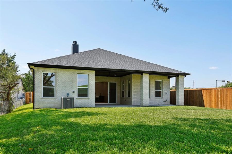 Rear view of property featuring a yard and a patio area